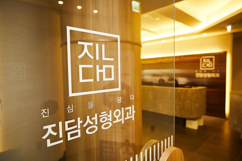 유리문의 진담성형외과 로고와 안내 데스크